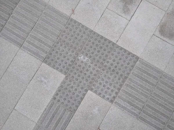 Grey tactile paving with domes and bars on a pavement in China